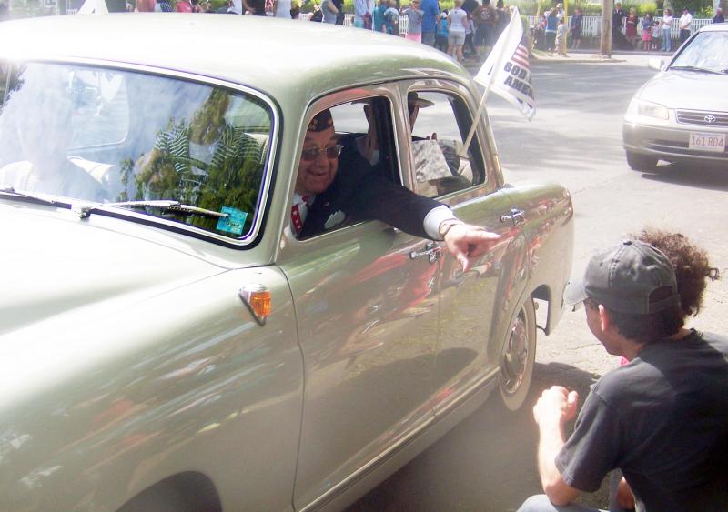Post Chaplain Joseph Napoli greets a parade spectator from inside his classic Mercedes. BY MATTHEW BERNAT